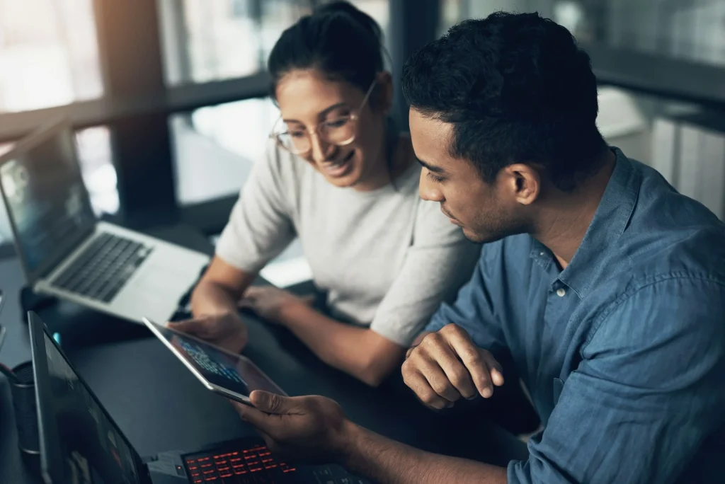 shot-of-two-young-workers-using-a-digital-tablet-in-a-modern-office